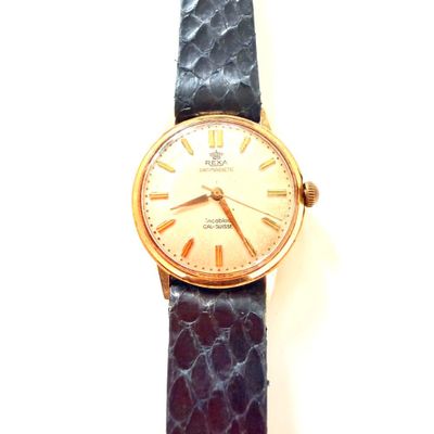 une image représentant une montre en or avec un bracelet violet sur fond blanc