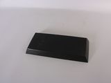 un petit objet noir sur une surface blanche