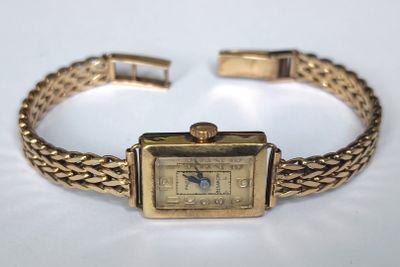 l'image d'une montre-bracelet en or entourée d'une chaîne