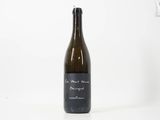 une bouteille de vin posée sur une table blanche