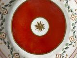 someone is holding a plate with a red center and a white center