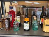de nombreuses bouteilles d'alcool sur une étagère dans un magasin