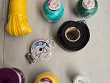 many different colored threads and spools on the floor