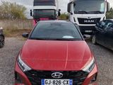 une voiture rouge garée à côté d'un camion