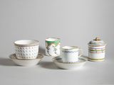three cups and a saucer are sitting on a table
