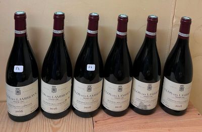 six bottles of wine are lined up on a wooden table