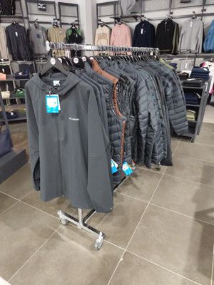 un portemanteau dans un magasin de vêtements, sur lequel sont suspendus des vêtements