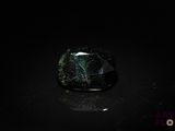 une pierre noire et verte posée sur une surface noire