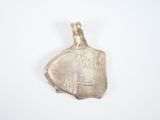 an image of a silver pendant with writing on it on a white surface