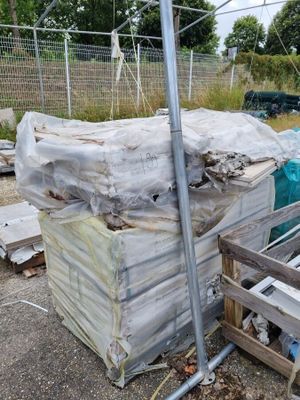 un tas de bois posé par terre à côté d'une clôture