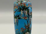 a blue vase with a painting of flowers on it