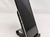 a close up of a cell phone on a stand on a white surface