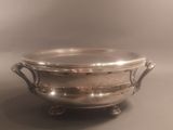 an antique silver plate with handles and handles on a stand
