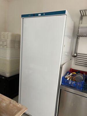 a refrigerator in a kitchen with a lot of dishes on the counter