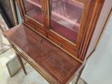a wooden cabinet with a glass door on top of it