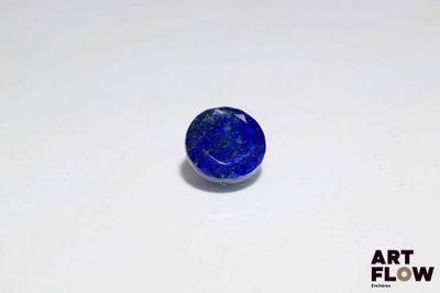 une pierre bleue posée sur une surface blanche