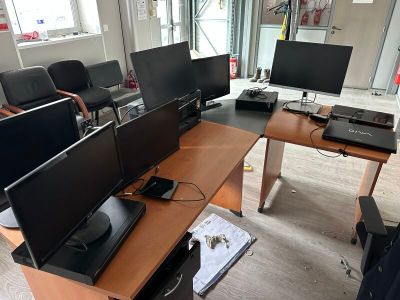 three computer monitors sitting on a desk in a room
