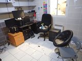 a room with a desk, chair, computer monitor, and other items