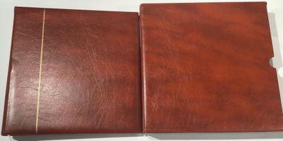 two brown leather folders sitting on top of a white table