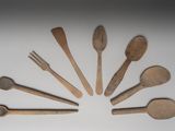 plusieurs cuillères et fourchettes en bois disposées en cercle sur une surface blanche