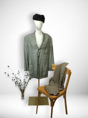 a mannequin sitting next to a chair with a suit on it