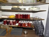 many cups of coffee on the shelves in the kitchen