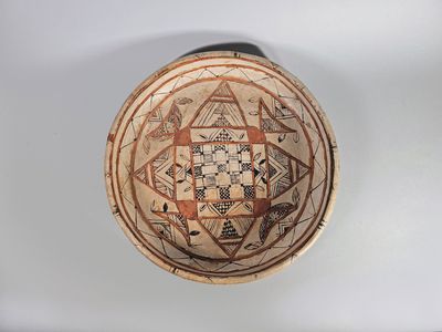 Plat circulaire en terre cuite engobée et peinte de motifs g…