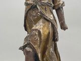 bronze statue of a woman holding a bird on a wooden base
