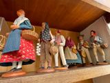 many figurines of people standing on a shelf