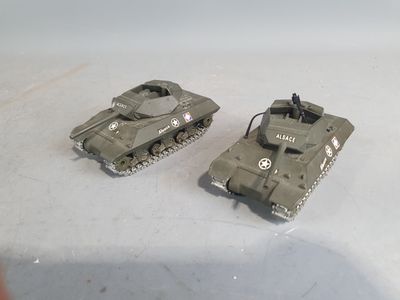 two toy tanks sitting next to each other on a table