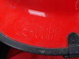 a close up of a red grill with a black handle
