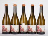 quatre bouteilles de vin sont alignées sur une surface blanche