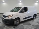 la camionnette blanche est garée sur un sol carrelé en damier