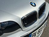 a silver bmw car parked on the side of the road
