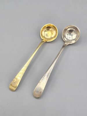 deux cuillères en argent posées l'une à côté de l'autre sur une table