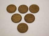six coins are arranged in a triangle on a white surface