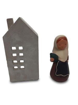 figurine représentant une femme avec une maison et une maison