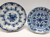 pair of blue and white plates with flowers on them on a white surface