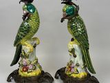 pair of green and yellow parrots on pedestals on a white background