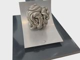 a sculpture of a human head on top of a sheet of paper