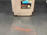 Un vieux jeu Nintendo est posé sur une table, à côté d'une pièce de monnaie.