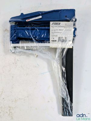une image représentant une agrafeuse bleue posée sur un morceau de plastique