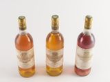 three bottles of wine sitting next to each other on a white surface
