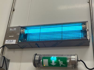 une lampe bleue accrochée au mur à côté d'un briquet