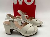 une paire de chaussures blanches pour femme, avec une boîte rouge en arrière-plan