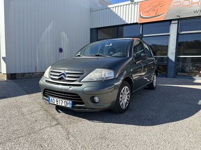 La voiture est garée devant l'immeuble, sur le parking.