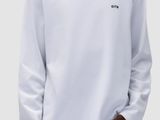 a man wearing a white sweatshirt and jeans standing in front of a white background