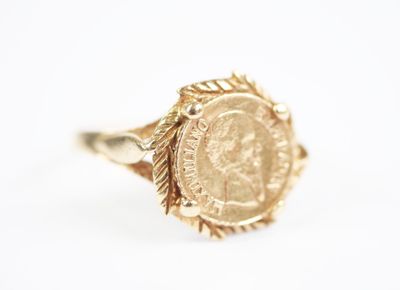 a close up of a gold ring with a coin on it