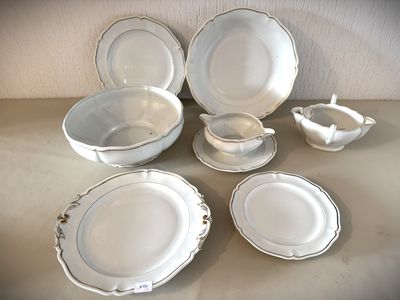 une table sur laquelle se trouvent beaucoup d'assiettes et de bols