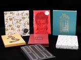 Quatre boîtes de chocolats sont alignées sur une surface noire